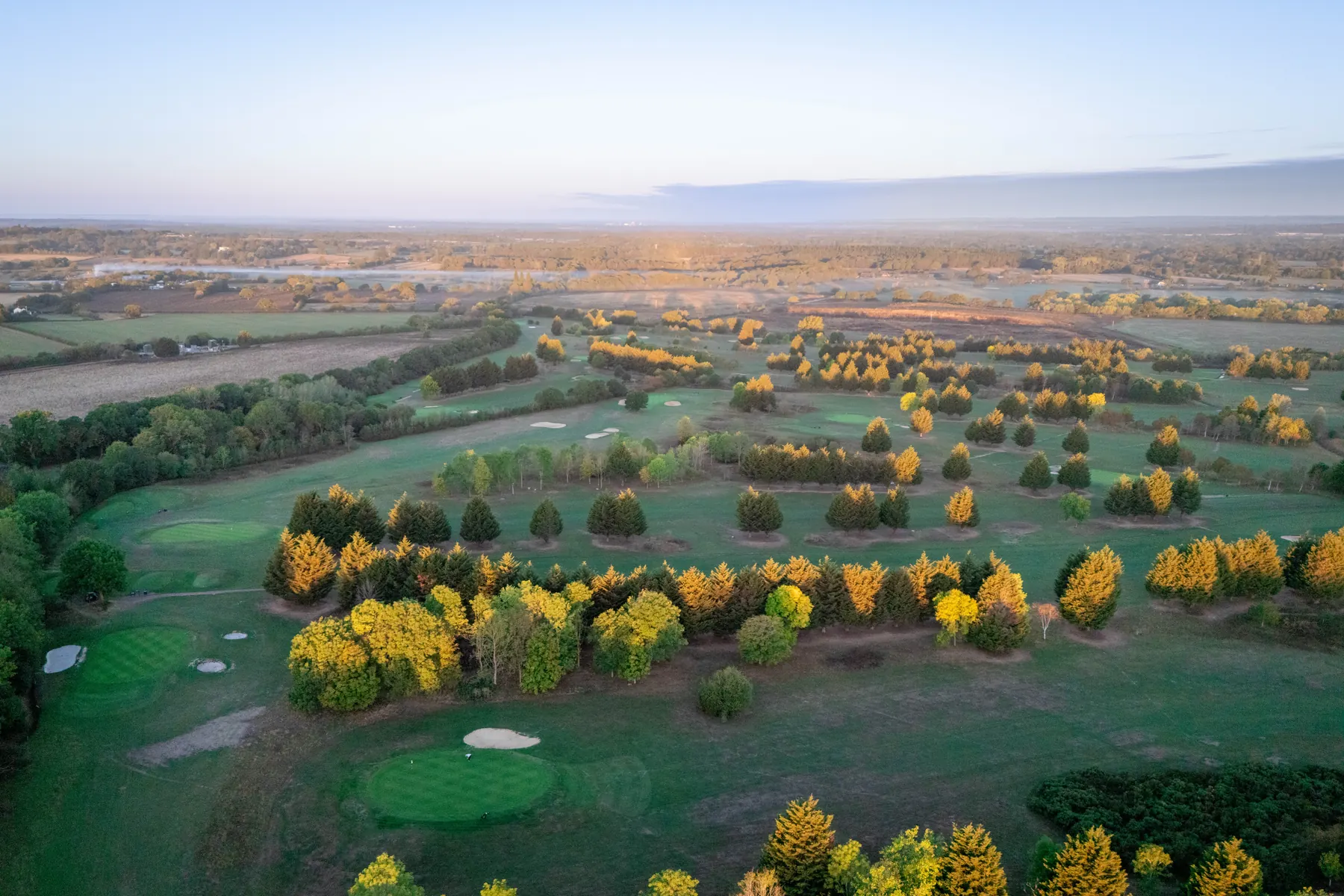 The course from the air at sunrise, autumn colour in the trees