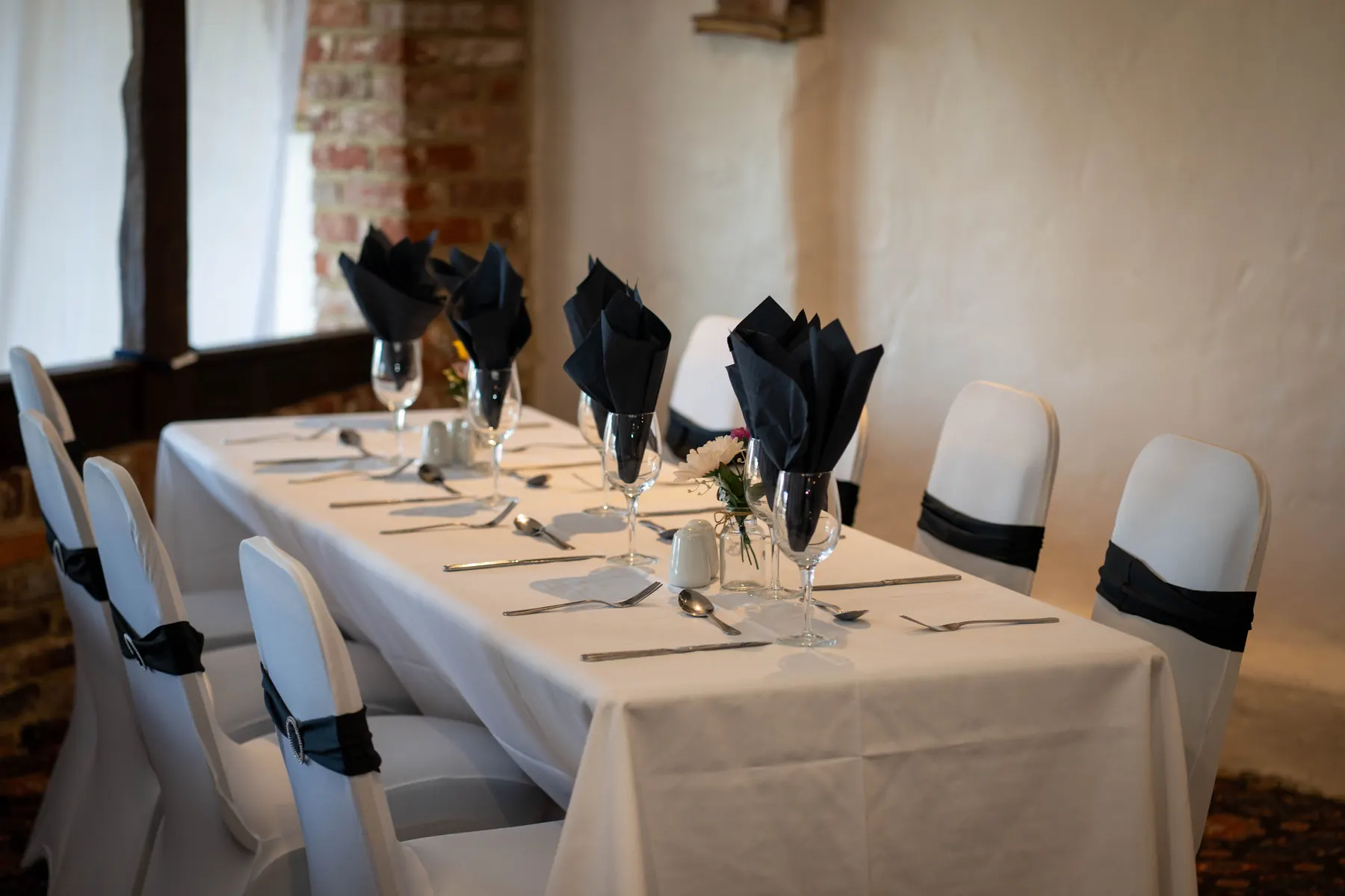 A long table laid with navy napkins and white chair covers