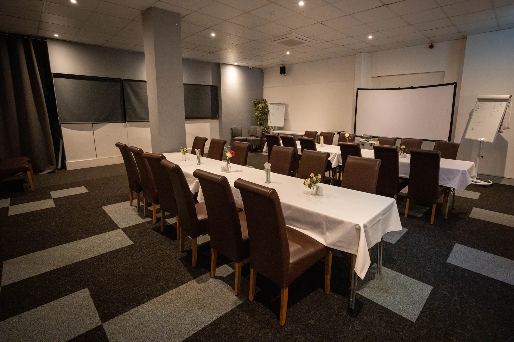 Long tables in the Hills Bar, with a flip chart and screen ready